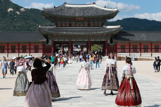 12일 오후 서울 종로구 경복궁에서 '퓨전한복'을 입은 관광객들이 기념사진을 찍고 있다.  종로구는 문화재청에 퓨전한복을 고궁 무료입장 대상에서 제외해달라고 요청할 계획이었지만 반대에 부딛치고 있다. 지역 한복대여업체, 한복 착용자 할인 혜택을 적용하고 있는 음식점 등을 중심으로 퓨전한복 혜택 폐지에 난색을 표하고 있다.